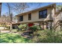 Charming two-story home with a stone facade, red door, and lush landscaping at 4614 Winthrop Dr, Atlanta, GA 30337