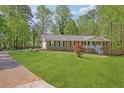 Lovely single-story home with a long drive and a lush front yard and landscaping at 567 Shiloh Nw Rd, Kennesaw, GA 30144