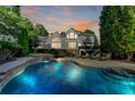 Luxury backyard oasis featuring a stunning pool, stone waterfall, and comfortable patio seating at 973 Meadow Club Ct, Suwanee, GA 30024
