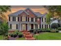 Charming two-story home with a brick facade, a manicured lawn, and professional landscaping at sunset at 973 Meadow Club Ct, Suwanee, GA 30024