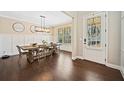 Elegant dining room with wood floors, wainscoting, a modern light fixture, and a large window at 1599 Benham Dr, Snellville, GA 30078