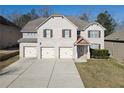 Charming two-story brick home featuring a three-car garage and well-manicured lawn at 7686 Brazos Trl, Fairburn, GA 30213