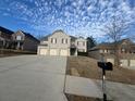 Traditional two-story brick home with a three car garage and a concrete driveway at 7686 Brazos Trl, Fairburn, GA 30213