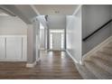 Bright foyer featuring a staircase, a front door with sidelights, and wood-look floors at 7686 Brazos Trl, Fairburn, GA 30213