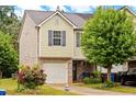 Attractive two-story townhome with a one-car garage, brick facade, and beautiful landscaping at 905 Magnolia Gardens Walk, Mcdonough, GA 30253