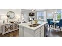 Open-concept kitchen features a large island with quartz countertops, stainless appliances, and a view into the living room at 355 Cherryhill Ln, Woodstock, GA 30188