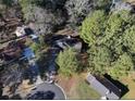 An aerial shot showcases a house with dark roof surrounded by trees and nestled in a quiet neighborhood at 2931 Oakwilde Ct, Snellville, GA 30039