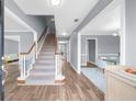 Bright entryway with hardwood floors, staircase, and view into the dining area at 310 Mulberry Manor Ct, Johns Creek, GA 30005