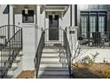 This lovely porch has steps leading up to the black iron gate and front door with a modern address at 145 Canton St, Alpharetta, GA 30009