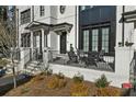 Close up shows the entrance to a white brick townhome with charming, black-framed windows and metal porch railing at 145 Canton St, Alpharetta, GA 30009