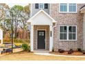 Inviting front entrance with a stylish black door, brick facade, and a well-maintained landscape at 1730 Fulmont Cir, Mableton, GA 30126