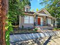 Charming home with a red front door, dormer windows, and a wrought iron railing on the covered front porch at 673 Pearce Sw St, Atlanta, GA 30310