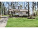 Single-story home with manicured lawn and simple landscaping surrounding foundation at 881 Brighton Dr, Lawrenceville, GA 30043