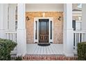 Covered front porch with brick accents and elegant black front door at 1102 White Cloud Rdg, Snellville, GA 30078