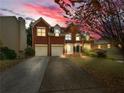 Charming two-story red brick home featuring an attached two-car garage under a dusk-filled sky at 3195 Vickery Ne Dr, Marietta, GA 30066