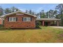 Traditional brick ranch-style home featuring a covered carport and mature trees in the front yard at 2630 Colonial Dr, College Park, GA 30337