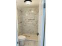 Bathroom with a tiled shower, built-in shelf and sleek fixtures, for convenient storage at 4941 Isle Royal Ct, Stone Mountain, GA 30088