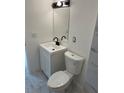Updated powder room with a white vanity, black fixtures, modern lighting, and tile flooring at 4941 Isle Royal Ct, Stone Mountain, GA 30088