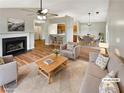 Inviting living room featuring a fireplace, ceiling fan, and an open floor plan leading to the kitchen and dining area at 2328 Wavetree Nw Ln, Acworth, GA 30101