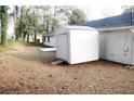 Simple backyard with the back of the home and a shed with a short ramp leading to the shed at 5928 Seam St, Lithonia, GA 30058