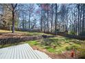 Spacious backyard featuring a deck, terraced landscaping, a wooden fence, and mature trees at 1121 Valley Ridge Se Ct, Marietta, GA 30067