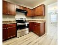 Well-lit kitchen with stainless steel oven, dark wood cabinets, and an open view to the living space at 2526 Piering Dr, Lithonia, GA 30038