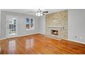 Bright living room featuring hardwood floors, a stone fireplace, and a door with window to the backyard at 3925 Keystone Nw Rdg, Acworth, GA 30101