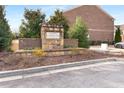 Entrance sign to Terraces at Cumberland community surrounded by landscaping and low brick wall at 2286 Emerald Sky Dr, Smyrna, GA 30080
