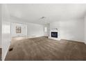 Spacious living room featuring neutral carpet, a fireplace, and white walls for a bright and airy feel at 277 Hope Dr, Dallas, GA 30157