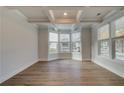Bright living room features hardwood flooring, coffered ceilings, and a bay window with lots of natural light at 4060 Andover Cir, Mcdonough, GA 30252