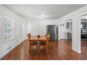 Bright dining room featuring hardwood floors, complemented by a stainless steel refrigerator and access to a modern kitchen at 2717 Hedgewood Nw Dr, Atlanta, GA 30311