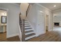 Hallway featuring wood-look floors, staircase and access to a bathroom with a pedestal sink at 4038 Andover Cir, Mcdonough, GA 30252