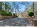 Long driveway leading to a charming home, framed by mature trees and brick detailing at 103 Eubanks Ct, Woodstock, GA 30188