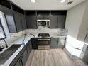 Modern kitchen with grey cabinets, stainless steel appliances, and marble countertops at 295 Lamden Ct, Lawrenceville, GA 30046