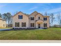 Charming two-story brick home featuring a manicured lawn and inviting front entrance at 209 Haverling Pass, Hampton, GA 30228