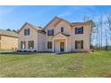 Charming two-story brick home featuring a manicured lawn and inviting front entrance at 209 Haverling Pass, Hampton, GA 30228
