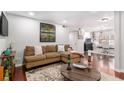 Open-concept living room with hardwood floors, modern artwork, and a glimpse of the kitchen and dining area at 64 Montre Nw Sq, Atlanta, GA 30327
