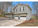 Side view of a two-story home with gray siding, a two-car garage, and a covered porch at 79 Mountain View Ct, Dallas, GA 30157