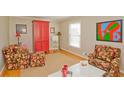 Cozy living room with hardwood floors, floral chairs, and a bright red cabinet at 4081 Deerwood Se Pkwy, Smyrna, GA 30082