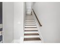 Entryway view of stairs with hardwood treads, white risers, and a wooden handrail at 577 Red Clay Farm Ln, Suwanee, GA 30024