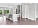 Open kitchen featuring a large island, stainless steel appliances, and luxury vinyl plank flooring at 577 Red Clay Farm Ln, Suwanee, GA 30024