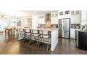 Modern kitchen island with white cabinets, granite countertops, stainless steel appliances, and breakfast bar seating at 475 Letchas Ln, Alpharetta, GA 30009