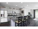 Modern kitchen with stainless steel appliances, gray cabinets, granite countertops, and a kitchen island with seating at 1221 Arnhem Dr, Hampton, GA 30228