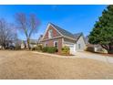 Brick and vinyl home with attached garage, long driveway and manicured lawn at 2955 Victoria Park Dr, Buford, GA 30519