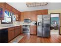 Kitchen featuring wooden cabinets, stainless steel appliances, and a view of the living room at 425 Ridgemont Dr, Lawrenceville, GA 30046