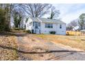 Cozy one-story home with a screened front porch and a cracked driveway leading up to the house at 122 Goldie Se Dr, Marietta, GA 30067