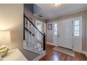 Foyer featuring a white front door with sidelights, hardwood floors, and a staircase at 1953 Graystone Pkwy, Grayson, GA 30017