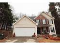 Charming two-story home with a brick and vinyl facade, a two-car garage, and a cozy front porch at 402 Rising Cir, Woodstock, GA 30189