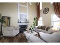 Spacious living room with a soaring ceiling, fireplace, hardwood floors, and elegant decor at 402 Rising Cir, Woodstock, GA 30189