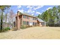 Traditional two-story brick house with an inviting entrance, shutters, and landscaping at 5020 Puritan Dr, Sugar Hill, GA 30518